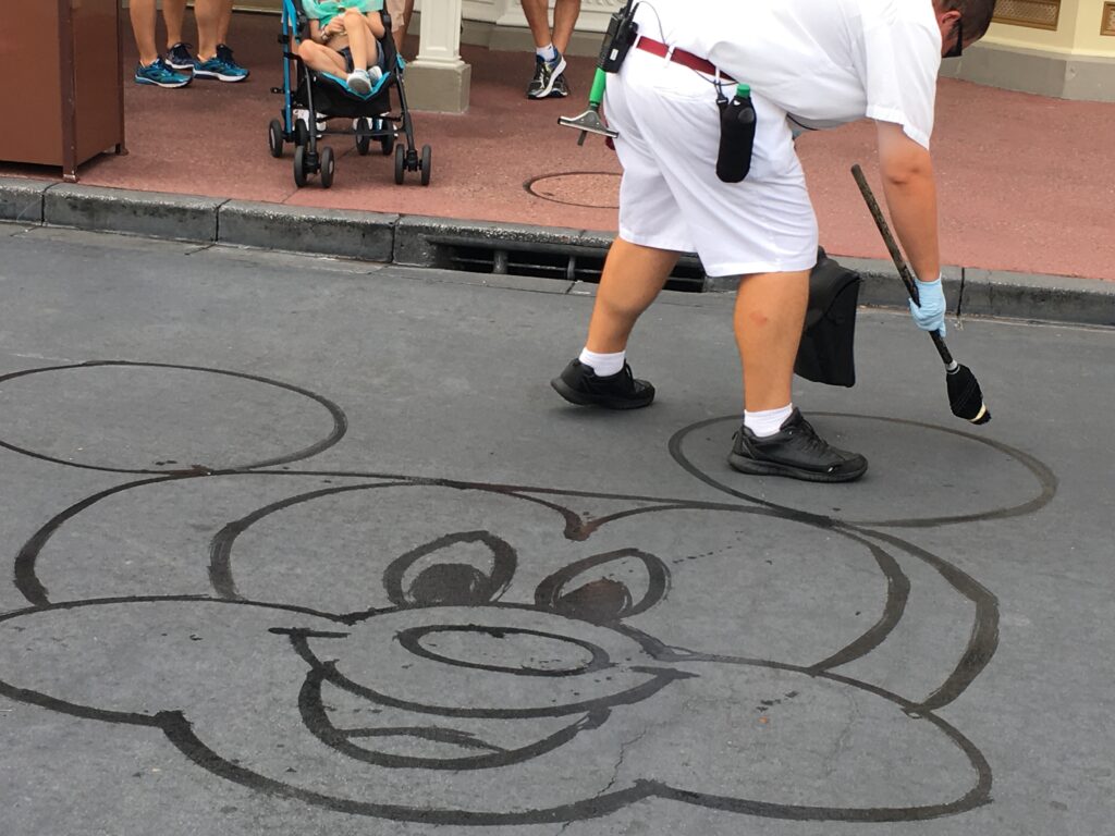 Disney Custodial Cast Member drawing Mickey with water